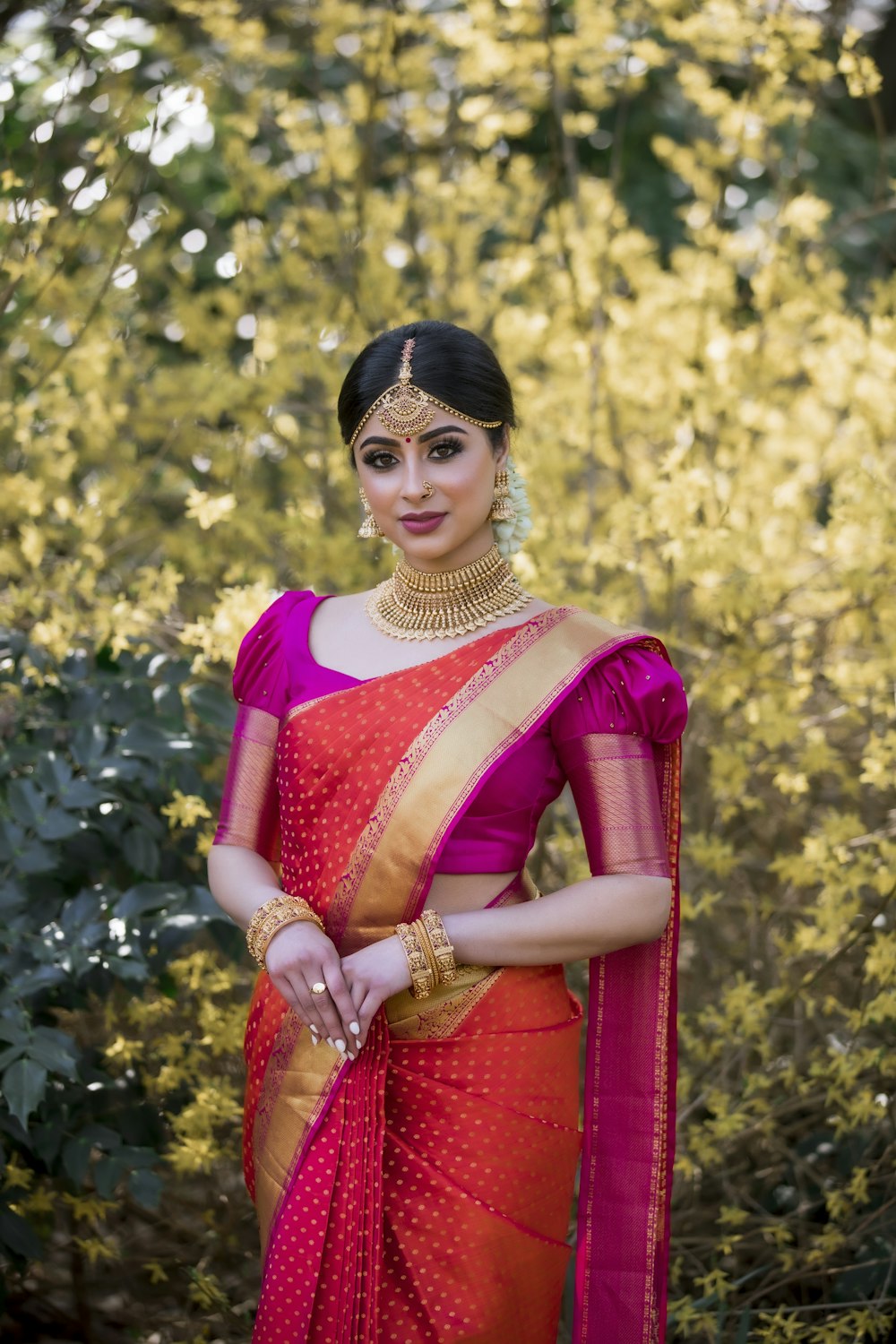 Red saree with white vine work under neem shade