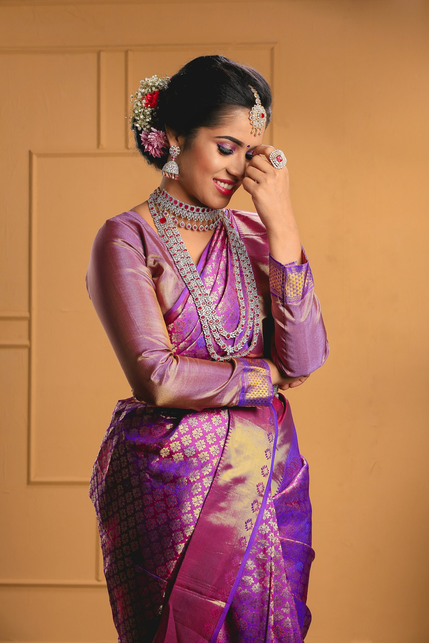 Bride in a purple-and-gold Katan silk saree, zari border at the wrist