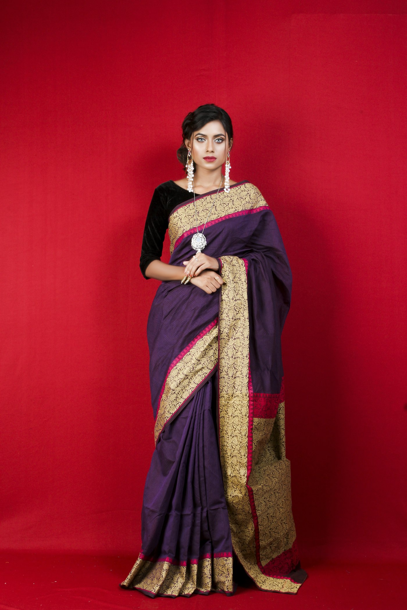 The Madanpura Jangla worn full-length — deep aubergine field, gold Kadhwa border